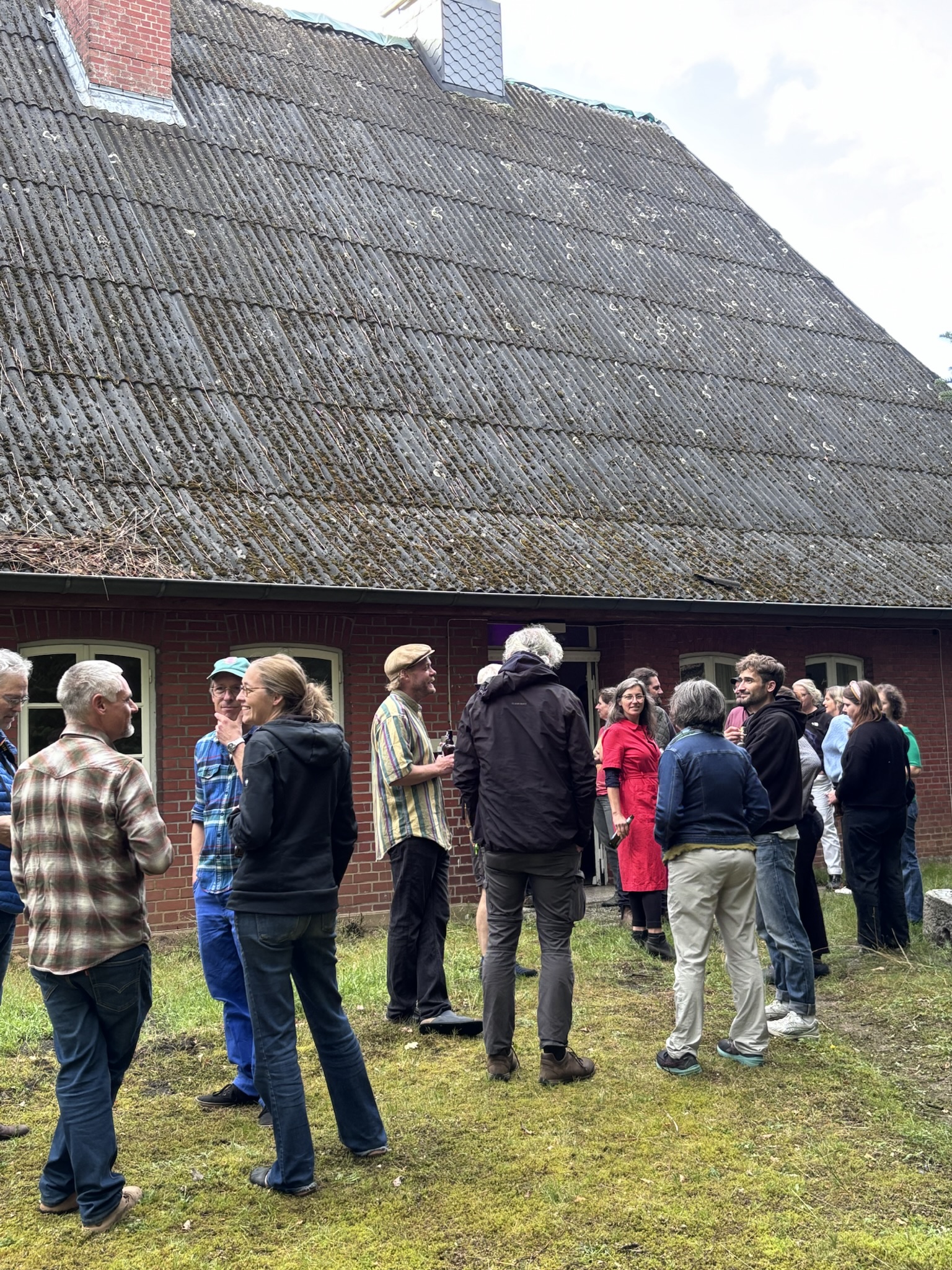 IMG_6320 Gäste der Filmvorführung vor dem Eingang in die Diele des Sassenhof auf dem Rasen