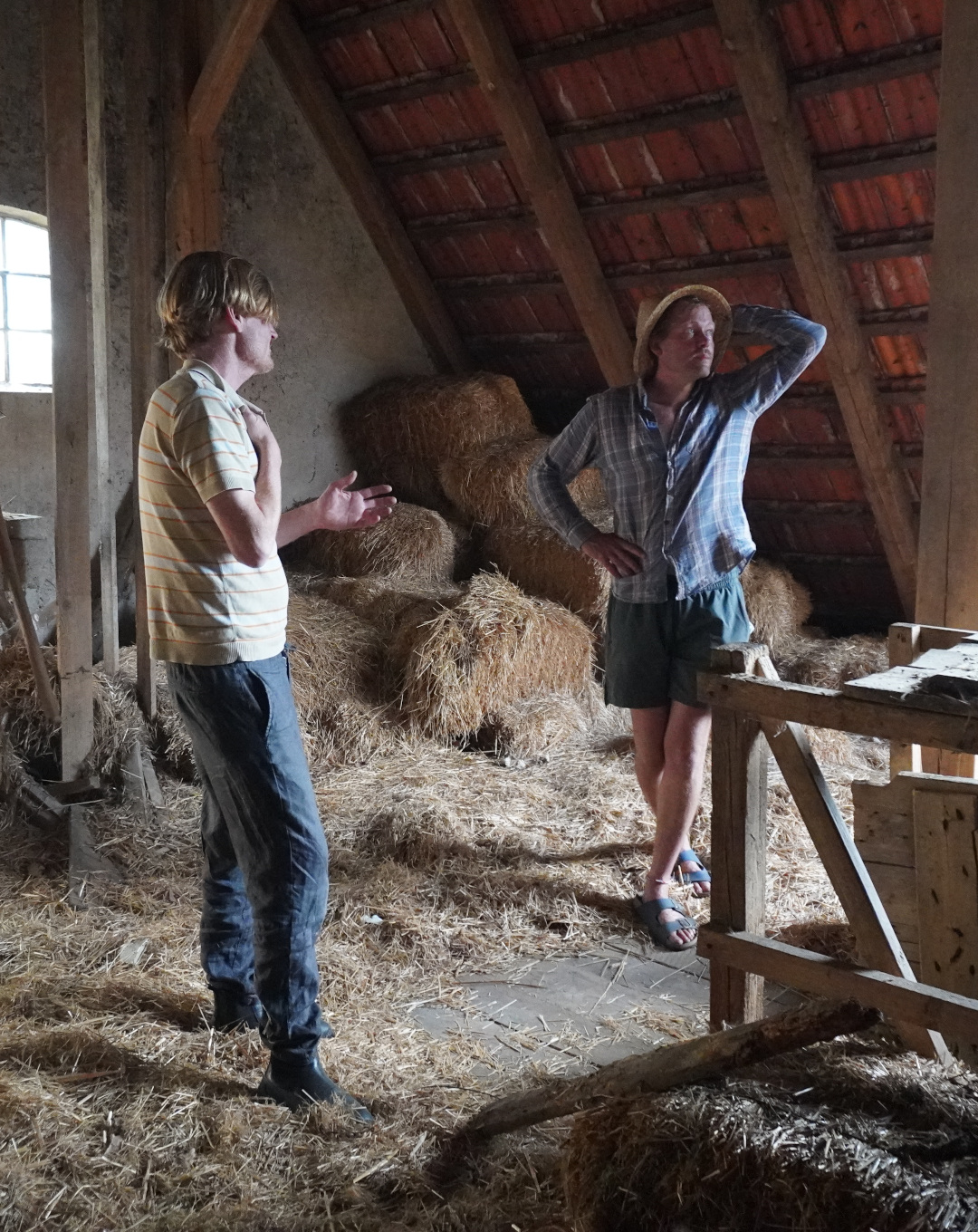 Zwei Personen auf dem Heuboden des Schweinestalls
